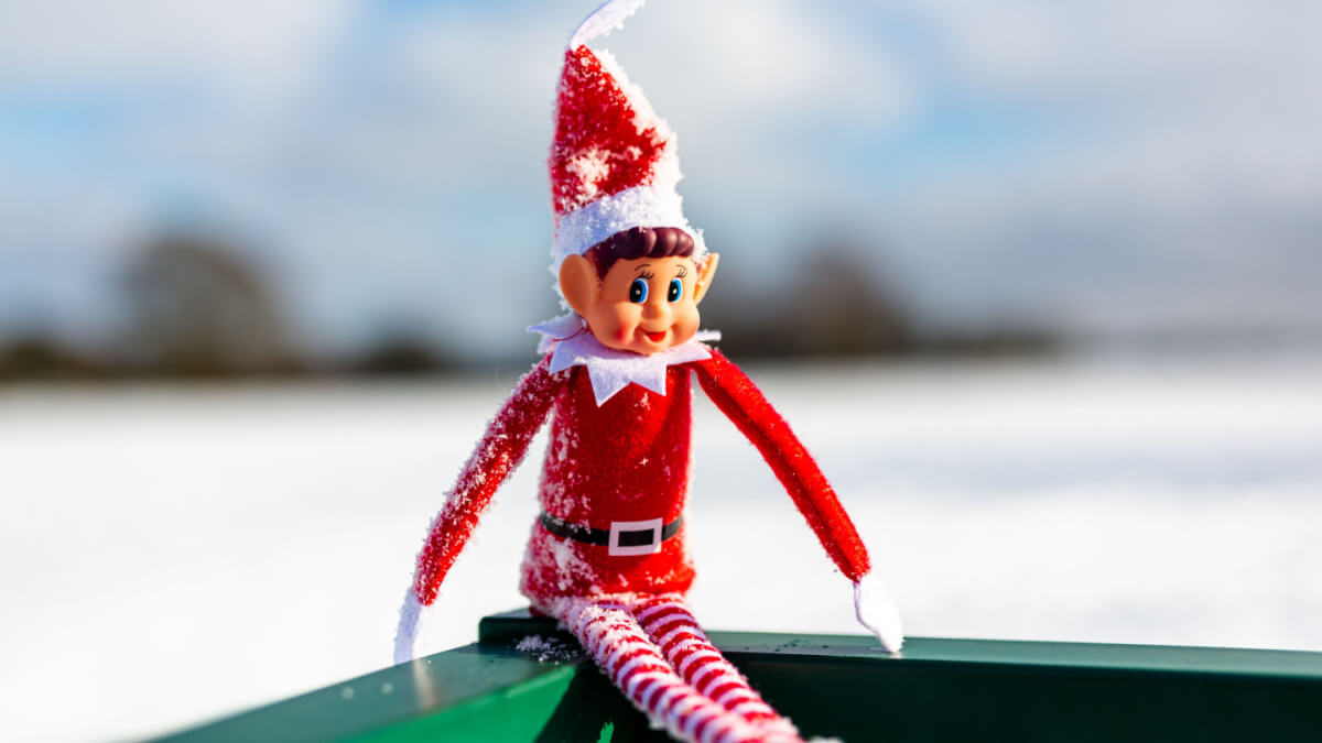 Elf On The Shelf sitting in the snow